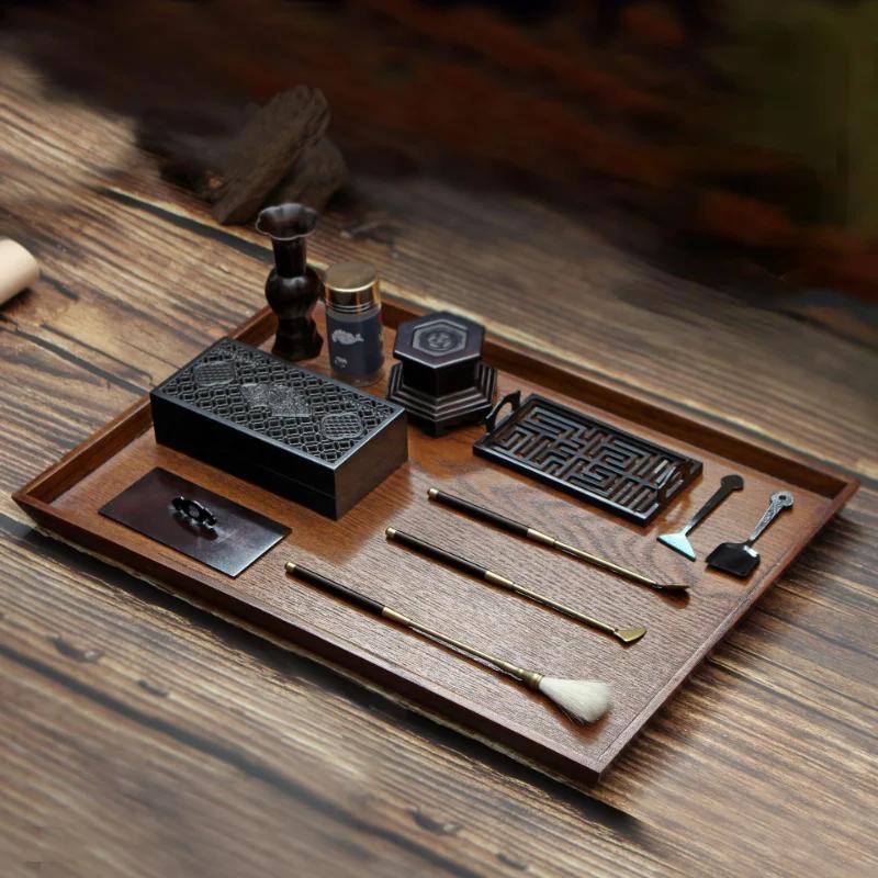 Plateau de rituel en bois avec kit d’encens premium et accessoires en cuivre, outils de manipulation disposés avec soin. Wooden ritual tray with a premium incense kit and copper accessories, handling tools arranged neatly.