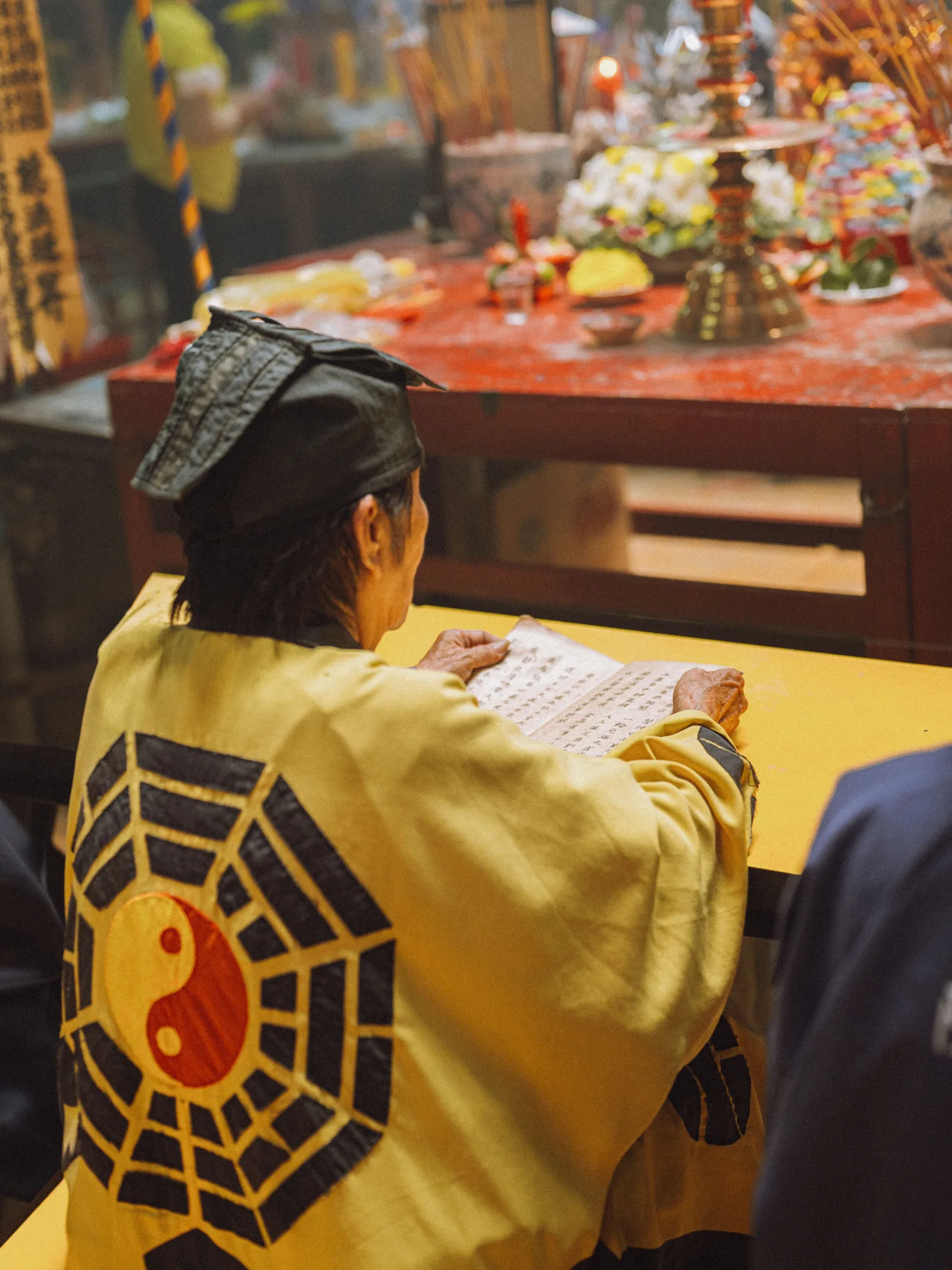 Worshiper at Taoist temple with Ba Gua (eight trigrams) symbol — traditional Taoist practice