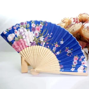 Éventail chinois pliant en soie, fond bleu roi avec grandes pivoines blanches et rose, branches de cerisier, bordure festonnée bambou