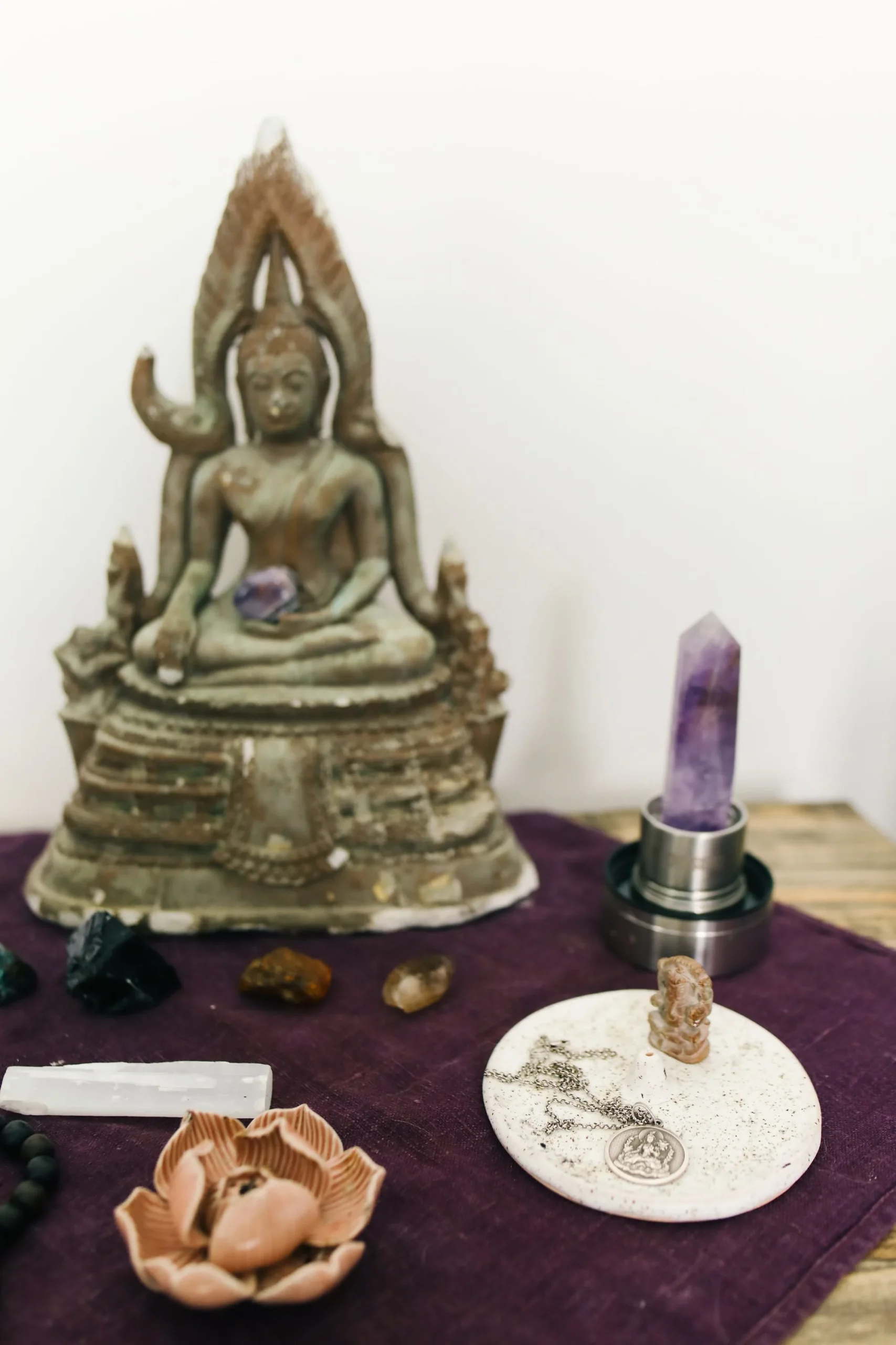 Simple Buddhist home altar with Buddha statue, incense holder, and ritual offerings
