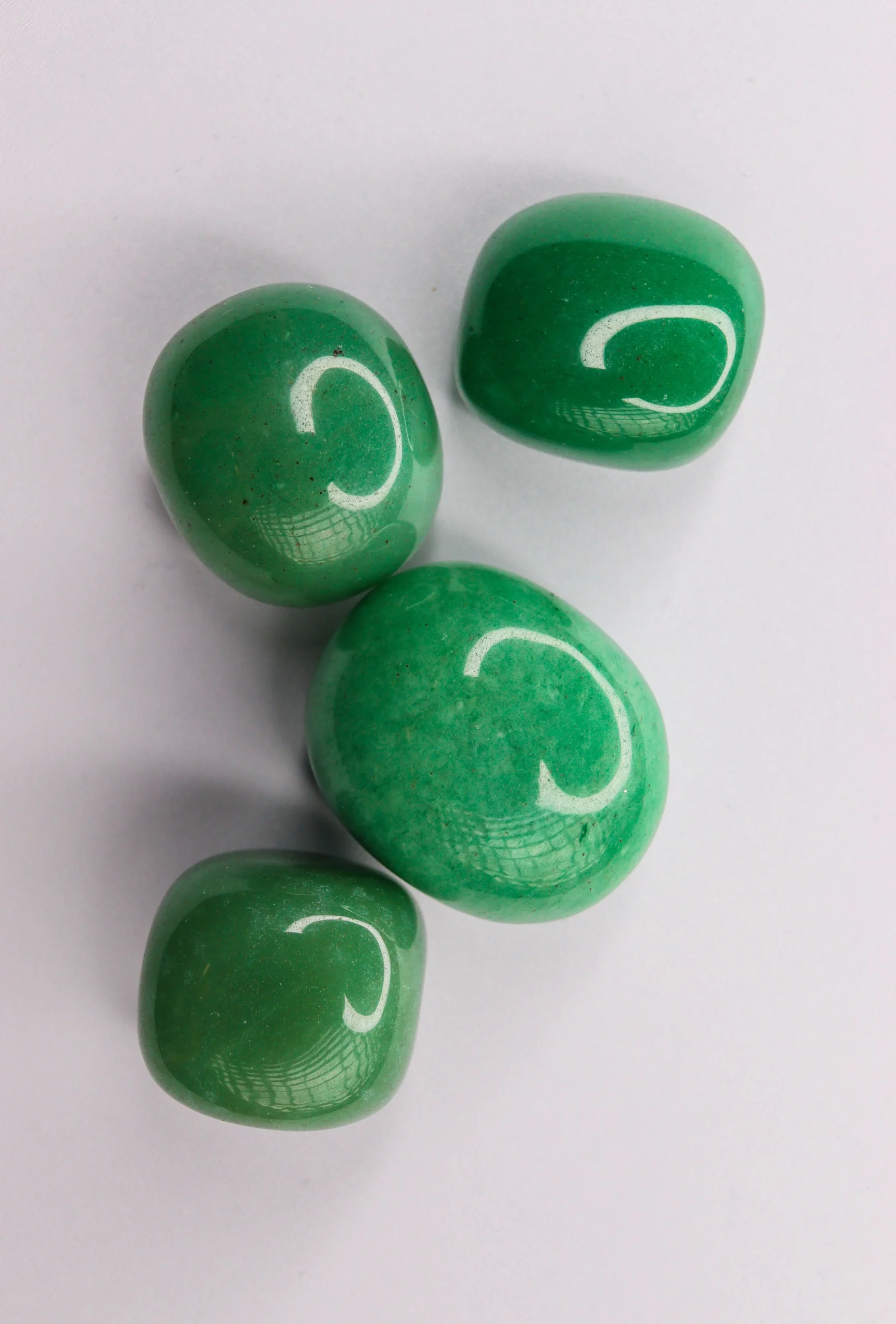 Polished nephrite jade stones from Mount Lushan, China — smooth river-worn surface, celadon green