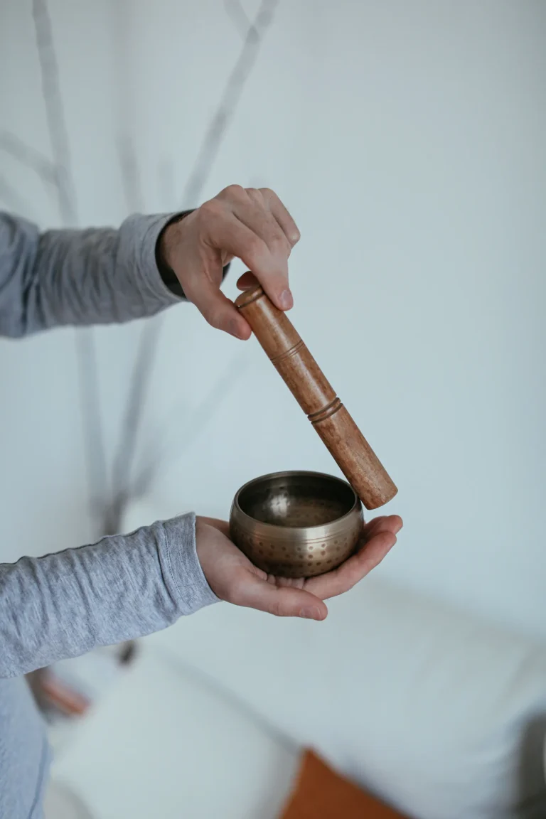 Tibetan copper singing bowl played with wooden mallet — sound healing practice, clockwise activation
